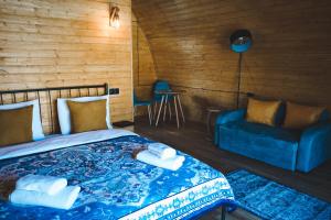 卡兹贝吉Kuro Glamping的一间卧室配有一张床和一张蓝色的沙发