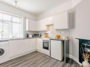 布罗德斯泰1 Bed in Broadstairs 89359的白色的厨房配有白色橱柜和洗碗机。