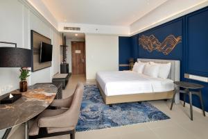 美娜多The Sentra Manado的一间卧室配有一张特大号床和一张书桌