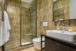 开普敦Neighbourgood 84 Harrington的浴室配有卫生间、盥洗盆和淋浴。