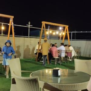 迈索尔Mannat Inn TS Mysore - Premium Homestay的一群人晚上坐在桌子旁