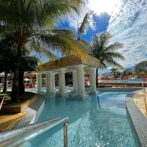 卡达斯诺瓦斯Lacqua DiRoma III com roupa de cama的一个带凉亭和棕榈树的游泳池