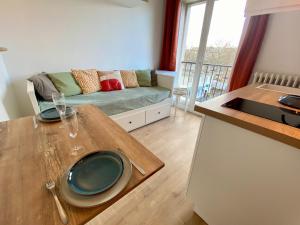 勒阿弗尔L'Escale Appartements et Suites en bord de Mer的厨房以及带桌子和沙发的客厅。