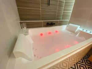 勒阿弗尔L'Escale Appartements et Suites en bord de Mer的白色浴缸内装红色的球