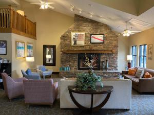 格林维尔AmericInn by Wyndham Greenville的带沙发和石制壁炉的客厅