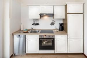 库克斯港Marbijes Appartementhaus的厨房配有白色橱柜和水槽