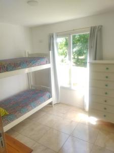 坦迪尔Los nogales的一间卧室设有两张双层床和一扇窗户。