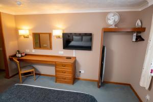 克利夫登Bridge Inn的客房设有书桌和墙上的电视。