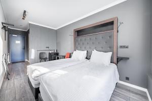 雷克雅未克Hotel Aska的一间卧室配有一张带白色床单的大床