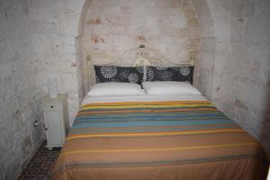 洛科罗通多trulli Annina的卧室配有一张石墙内的大床