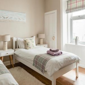 塞拉戴克Sea Sound的卧室配有白色床、两盏灯和一扇窗户。