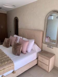 马拉喀什Appartement neuf climatisé, centre Marrakech.的一间卧室配有一张带粉红色枕头和镜子的床