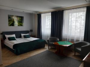普乌图斯克巴尔塔扎尔酒店的卧室配有床、桌子和窗户。