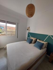 埃普拉特约布里加Sara's apartment Barcelona的一间卧室配有一张带蓝色枕头的大床