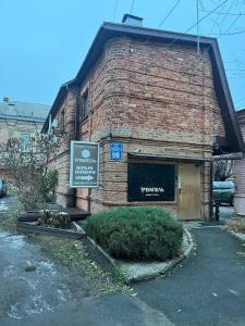 哈尔科夫Міні-готель Тремпель的砖砌的建筑,旁边标有标志