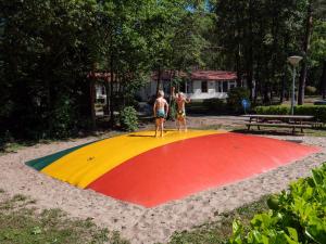 多廷赫姆Recreatiepark de Wrange的两个人站在公园里彩虹色圈上