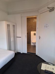 弗利辛恩Stad & Strandhotel Elisabeth的客房设有一张床和一间带卫生间的浴室