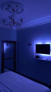 雅温得L'Integrale的蓝色的房间,配有床和电视