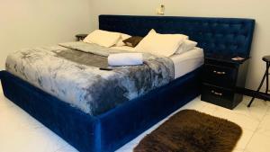 雅温得L'Integrale的卧室里一张蓝色的大床,带有蓝色床头板
