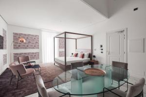巴勒莫Palazzo Sovrana的客厅配有玻璃桌和1张床