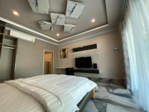 Ban PrasatSutalawadee Resort的一间卧室配有一张床和一台平面电视
