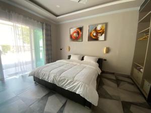 Ban PrasatSutalawadee Resort的卧室配有一张床,墙上挂有两幅画
