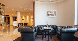 法兰肯塔尔弗兰肯塔尔维克多的宫殿酒店的一间设有皮革家具和桌子的等候室