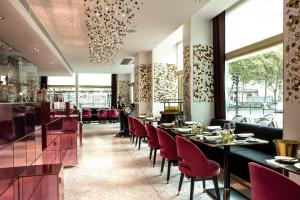 巴黎Fauchon l'Hôtel Paris的一间设有红色桌椅的餐厅和一间酒吧