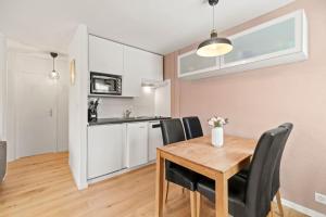 沙尔梅Appartement calme et accueillant à Charmey的厨房以及带木桌和椅子的用餐室。