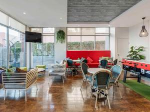 悉尼悉尼达令港宜必思酒店的配有桌椅和红色沙发的房间