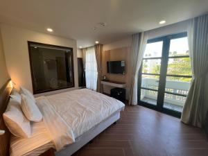 富国Tanya Phu Quoc Hotel的一间卧室设有一张床和一个大窗户