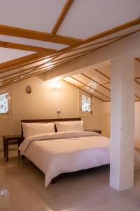 戴尔豪斯BluSalzz Villas - The Pine Tree, Dalhousie - Himachal Pradesh的卧室配有一张白色大床和木制天花板