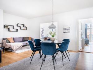 哥本哈根Sanders Leaves - Chic Three-Bedroom Apartment In Downtown Copenhagen的一间带桌子和蓝色椅子的用餐室