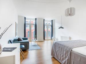 哥本哈根Sanders Leaves - Chic Three-Bedroom Apartment In Downtown Copenhagen的一间卧室配有一张床、一张沙发和一把椅子