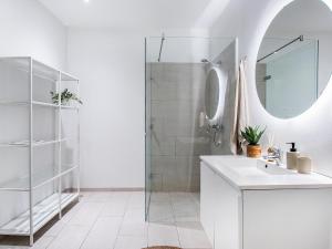 哥本哈根Sanders Leaves - Chic Three-Bedroom Apartment In Downtown Copenhagen的白色的浴室设有水槽和淋浴。