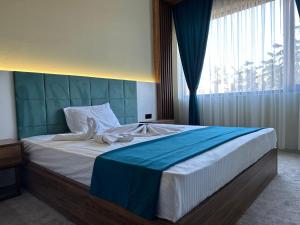尚勒乌尔法Kançul Hotel Taştepeler的一间卧室配有一张大床和蓝色床头板