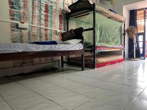 Fort KochiB Hostel的卧室配有双层床,铺有瓷砖地板。