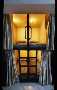 马尼拉C Place - Capsule A的配有窗帘的小客房内的双层床