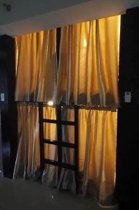 马尼拉C Place - Capsule A的窗帘前有梯子的窗户