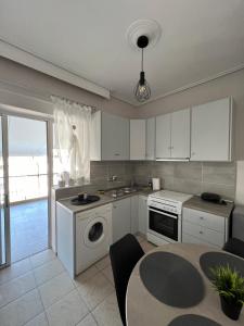 拉里萨TopCentral Apartment的厨房配有白色橱柜和一张桌子