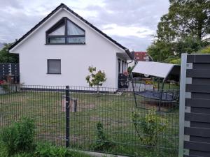 罗斯托克Ferienhaus Bojenweg的围栏后面的白色房子