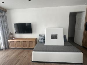 萨姆瑙恩Samnaun, ChaletdMot的一间卧室配有一张床和一台平面电视