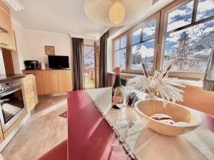 沃瑟姆阿尔伯格Hillside One - Ski-In Ski-Out Apartments am Arlberg的厨房配有带1瓶葡萄酒的桌子