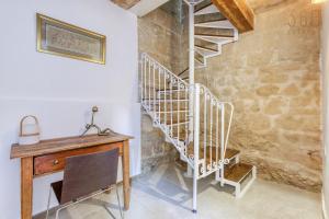 ŻebbuġCharming + Modern 1BR House in Historic Zebbug by 360 Estates的配有木桌的客房内的螺旋楼梯