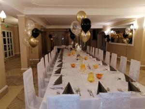 普乌图斯克巴尔塔扎尔酒店的长长的宴会桌,有黑色和金色气球