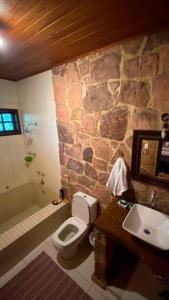 安达拉伊Pousada Casa Fraternità, viva momentos de tranquilidade em contato com a natureza.的浴室设有石墙、卫生间和水槽。