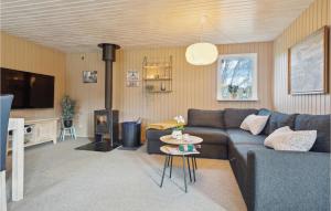 埃贝尔托夫特Amazing Home In Ebeltoft With Wifi的客厅设有蓝色的沙发和壁炉