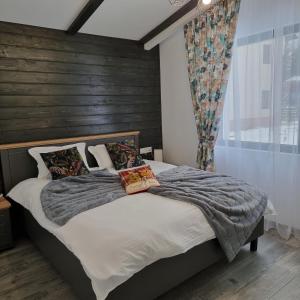 布什泰尼Chalet Amik的一间卧室设有一张带木墙的大床