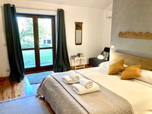 坎帕尼亚诺·迪罗马瑟兰拉度假屋的卧室配有带2条毛巾的窗户,位于床上