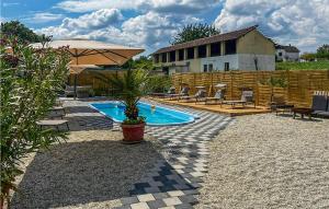 BudrovacBeautiful Home In Budrovac With Wi-fi的一个带盆栽和遮阳伞的游泳池